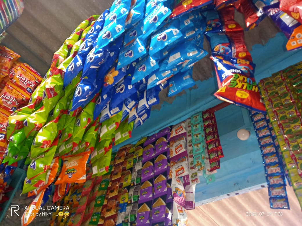 Display of fresh vegetables and packaged snacks in a small local grocery store with a welcoming market atmosphere